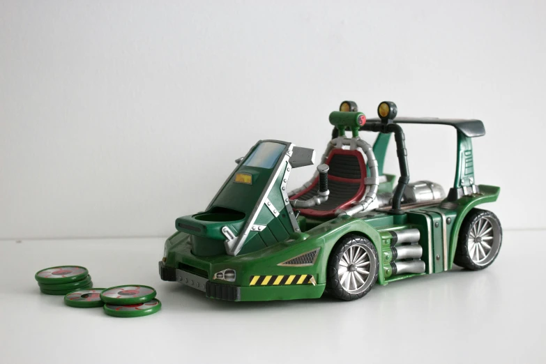 a green toy car with a steering wheel and lots of green coins