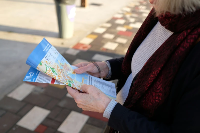 a woman wearing a red sweater is holding a map