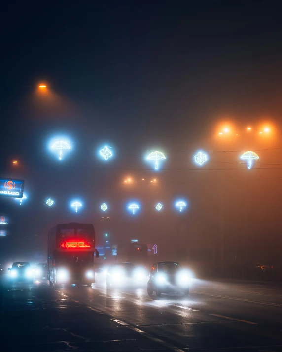 cars driving on a rainy street at night