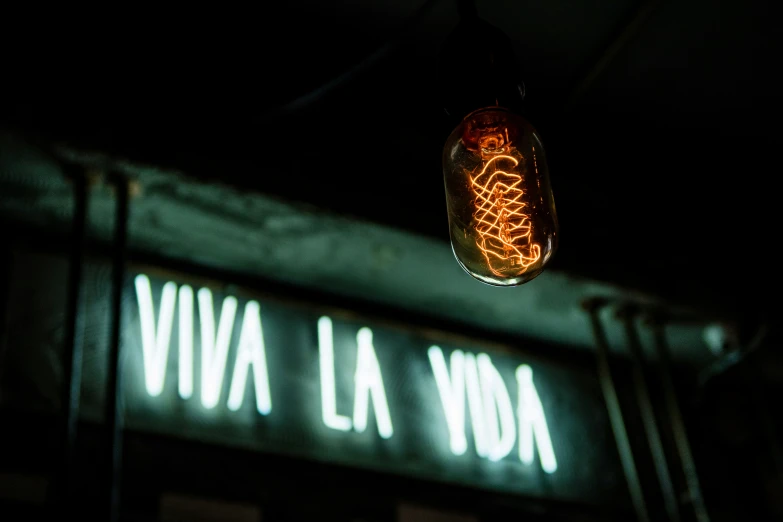 a streetlight with neon writing in the dark