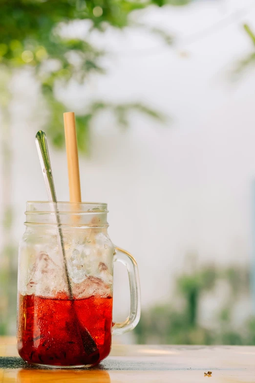 a jar full of water with two straws sticking out of it