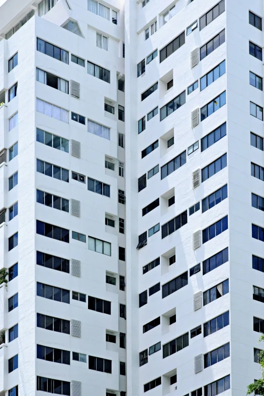 some tall white buildings next to trees and bushes