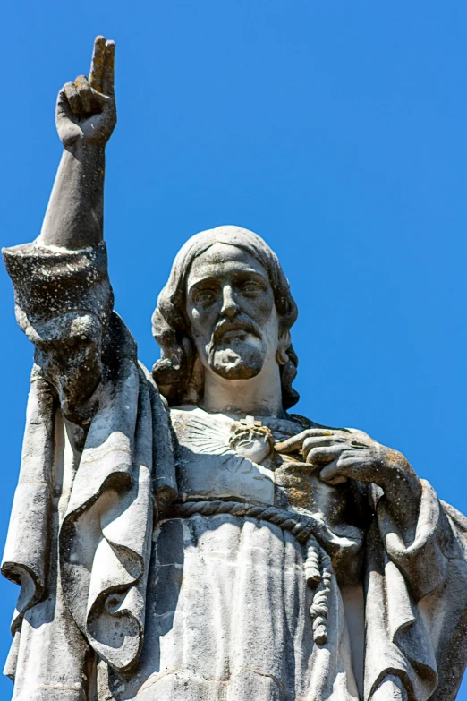 statue of a man in white holding up a finger