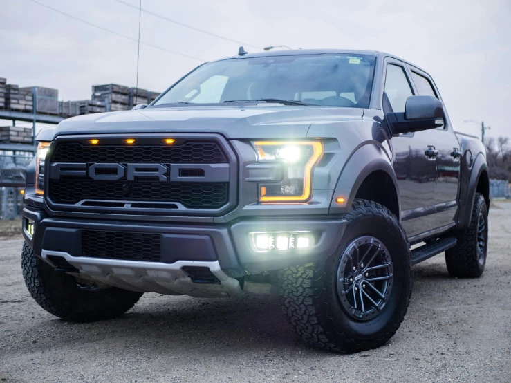 an all - new grey ford f - 150 pickup truck parked in an industrial yard