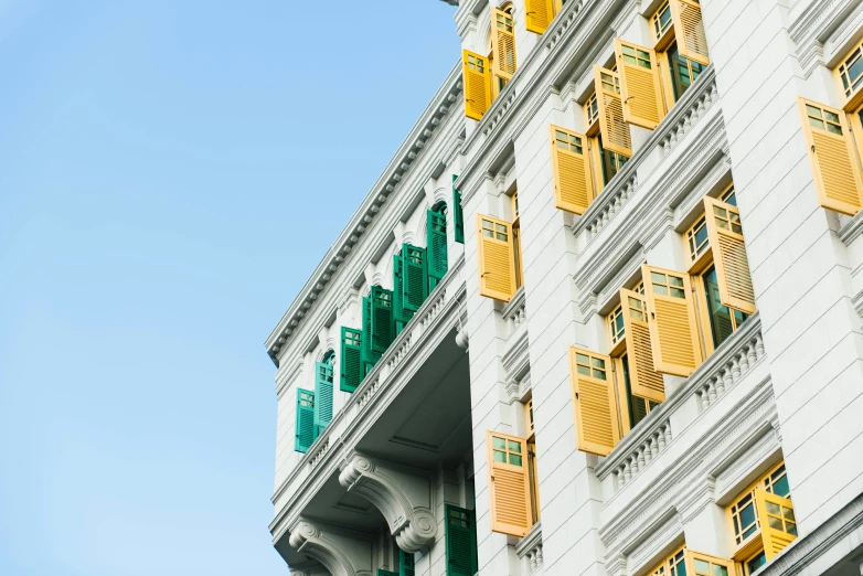 a building with yellow and green shutters on it