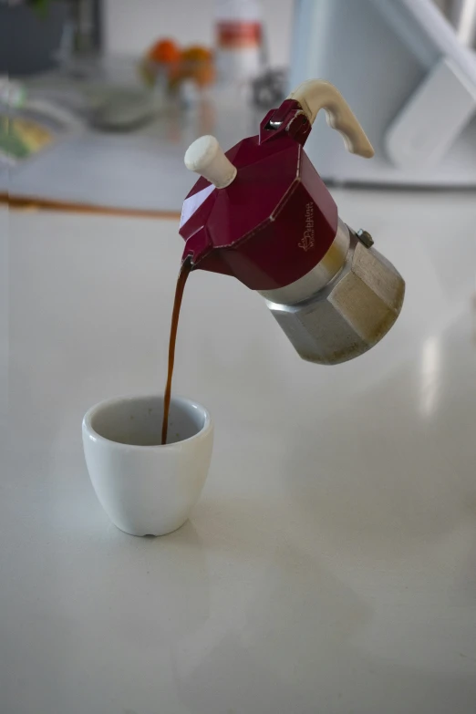 a cup with coffee being poured into it