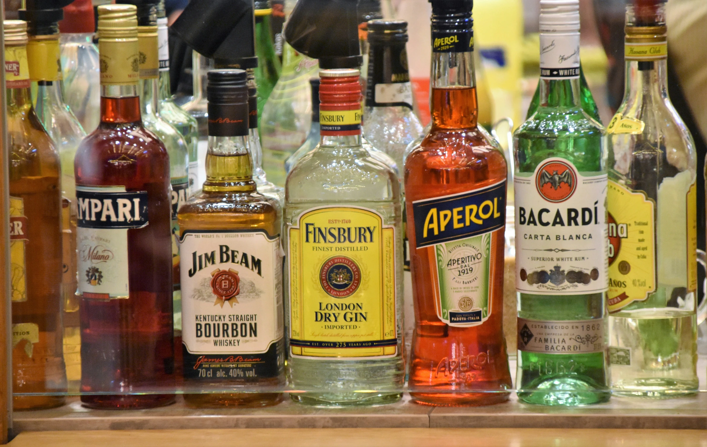 liquor bottles sitting on a shelf next to each other