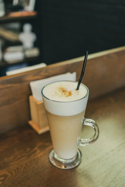 a glass of coffee with a drink straw on the edge