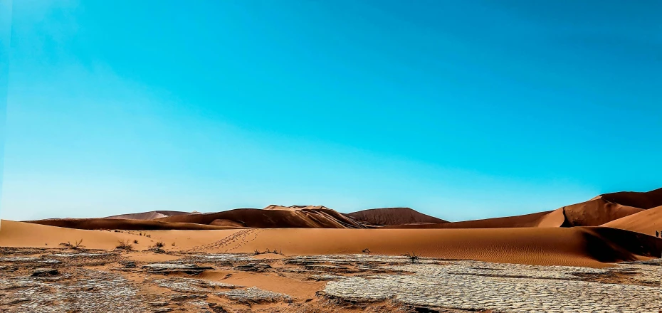 the desert is empty and blue with some clouds in the sky