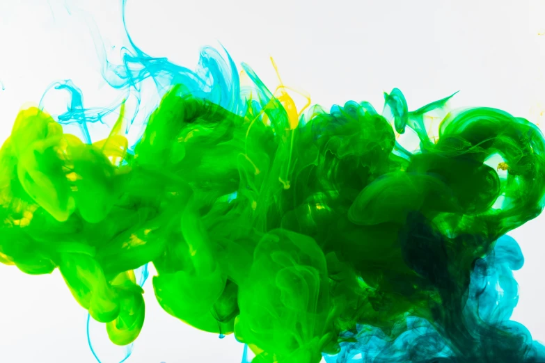colored ink flowing in water that is green and blue