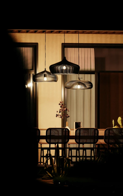 an illuminated dining table sits outside a window