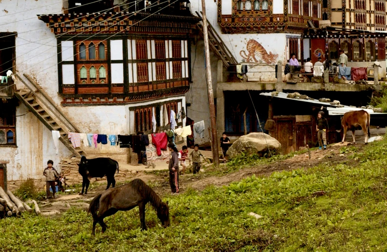 some people building some buildings with horses and laundry line up