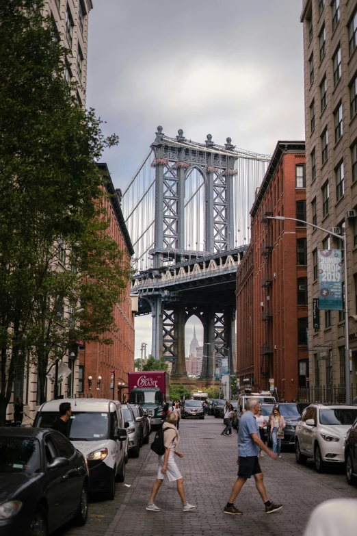 two people walking across the street in front of cars