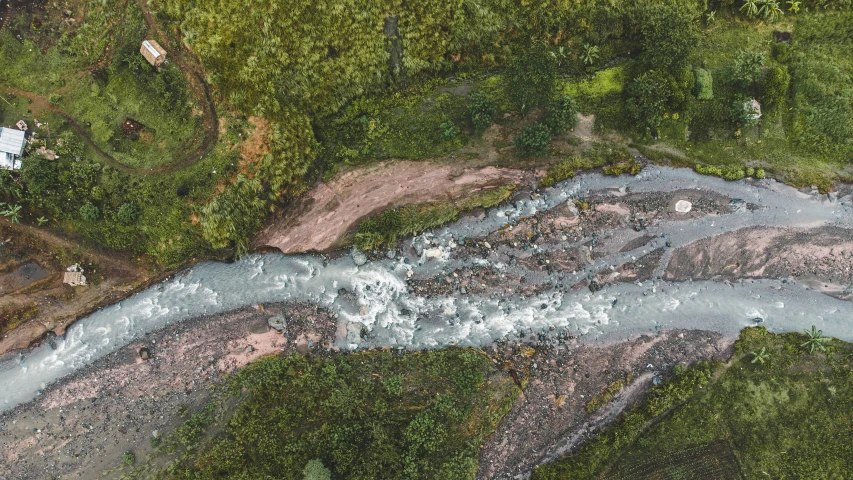 an aerial view of a river flowing through a lush green jungle