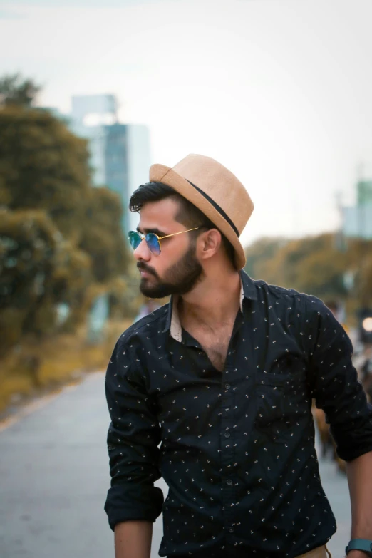 a man with glasses and a hat is standing next to a bike