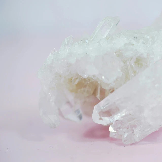 a pile of crystal rocks on a pink surface