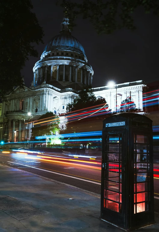 telephone booth on street next to dome at night