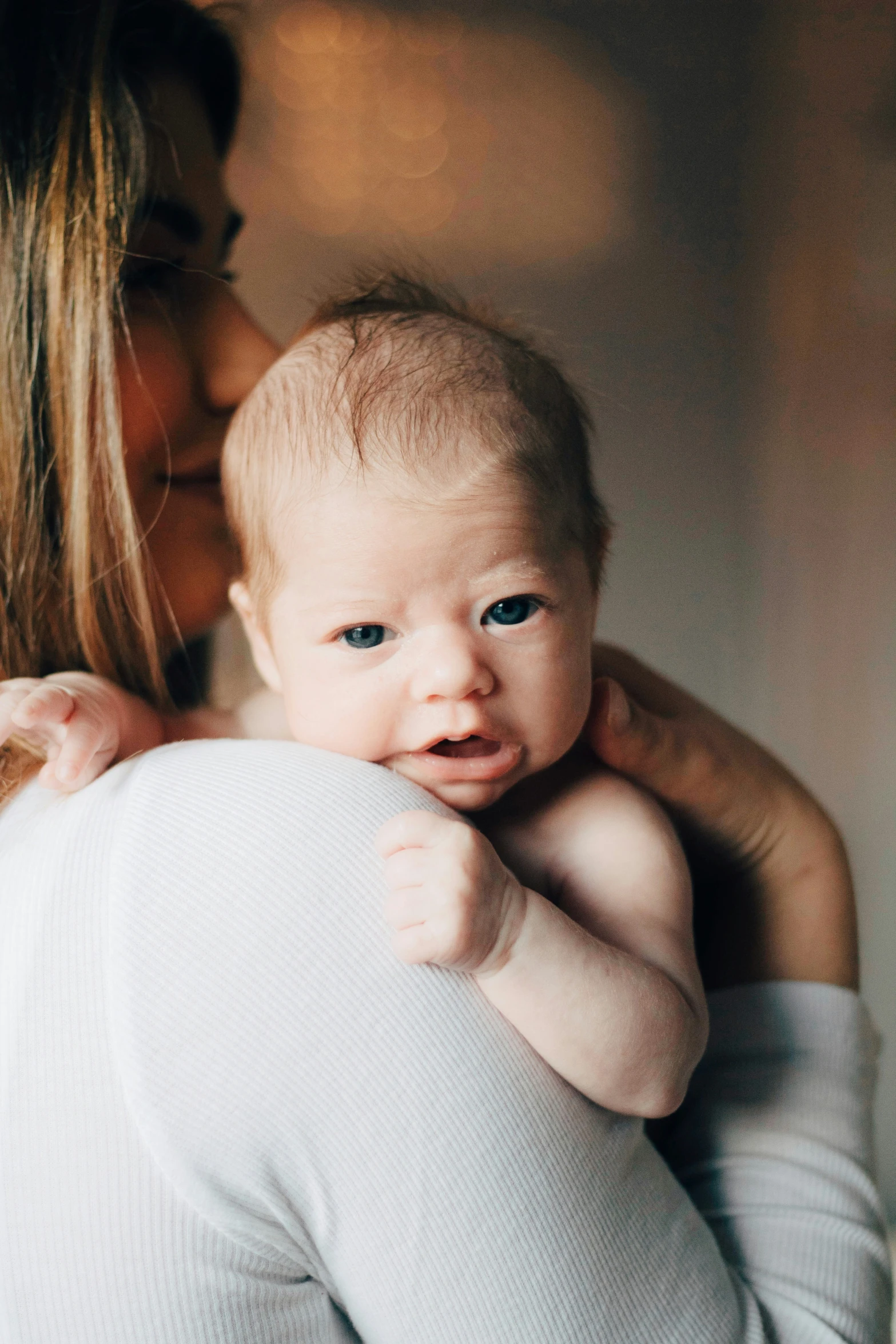 a woman is holding a newborn baby and he has his face on the mother's chest