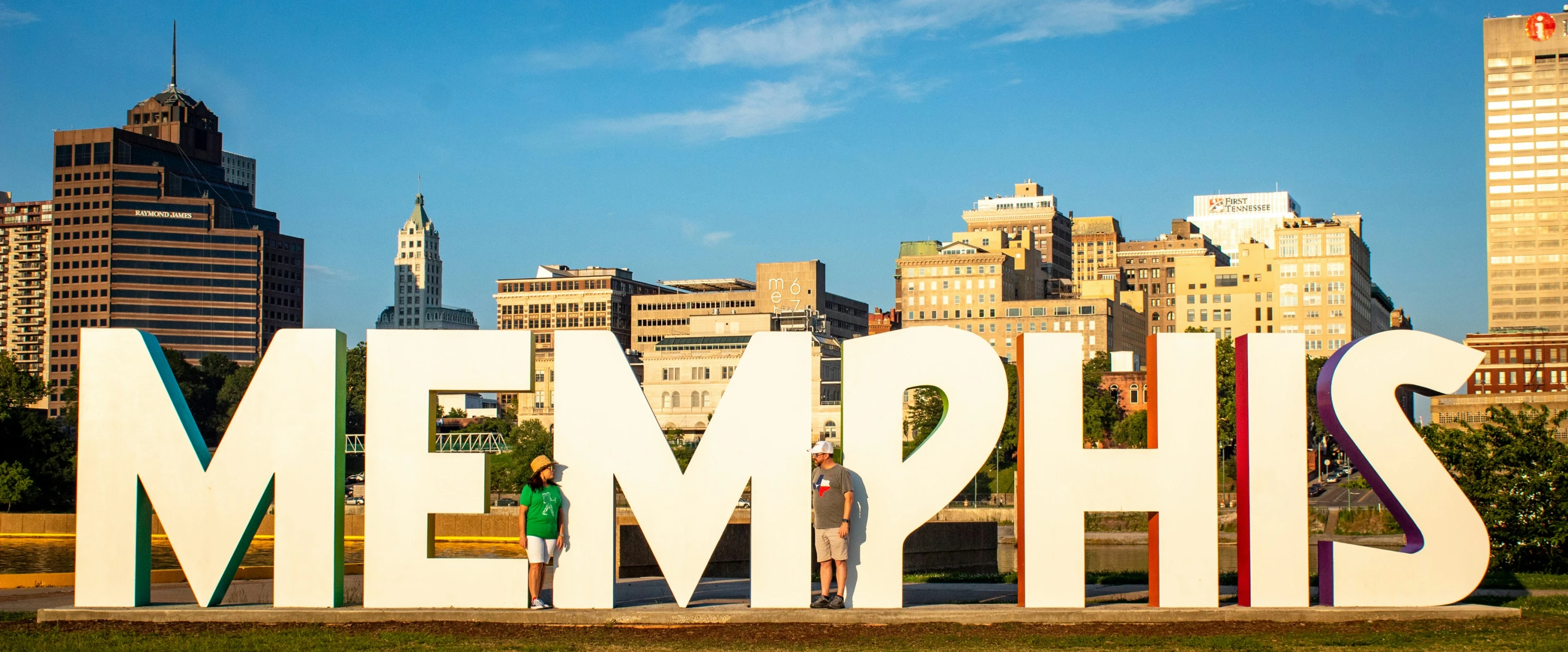 people pose for a picture in front of a giant metal sign