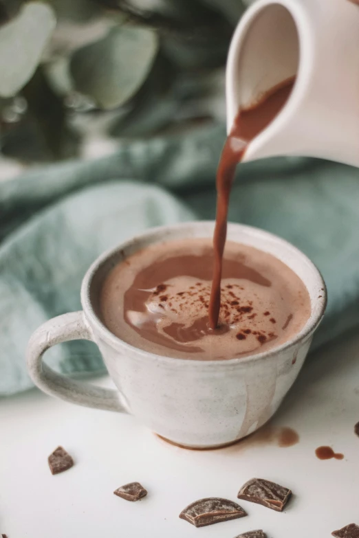 a cup of  chocolate being poured into it