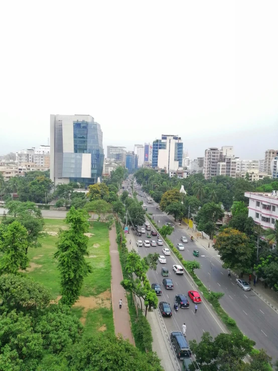 cars are driving down the road between tall buildings