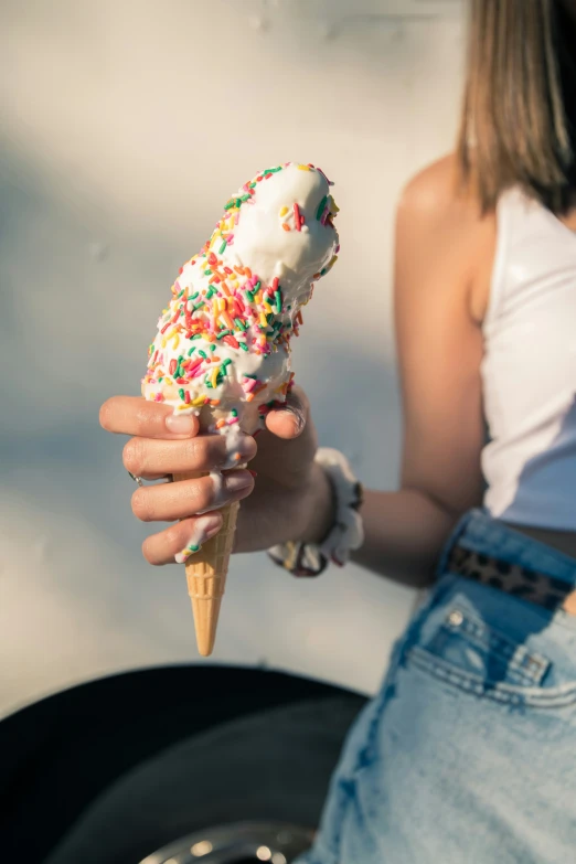 a person holding an ice cream cone filled with sprinkles