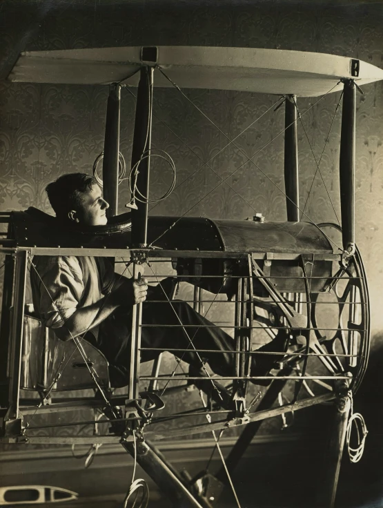 an old po shows a man sitting on a small aircraft