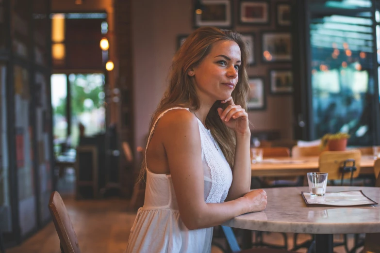 woman at table with drink and menu in background