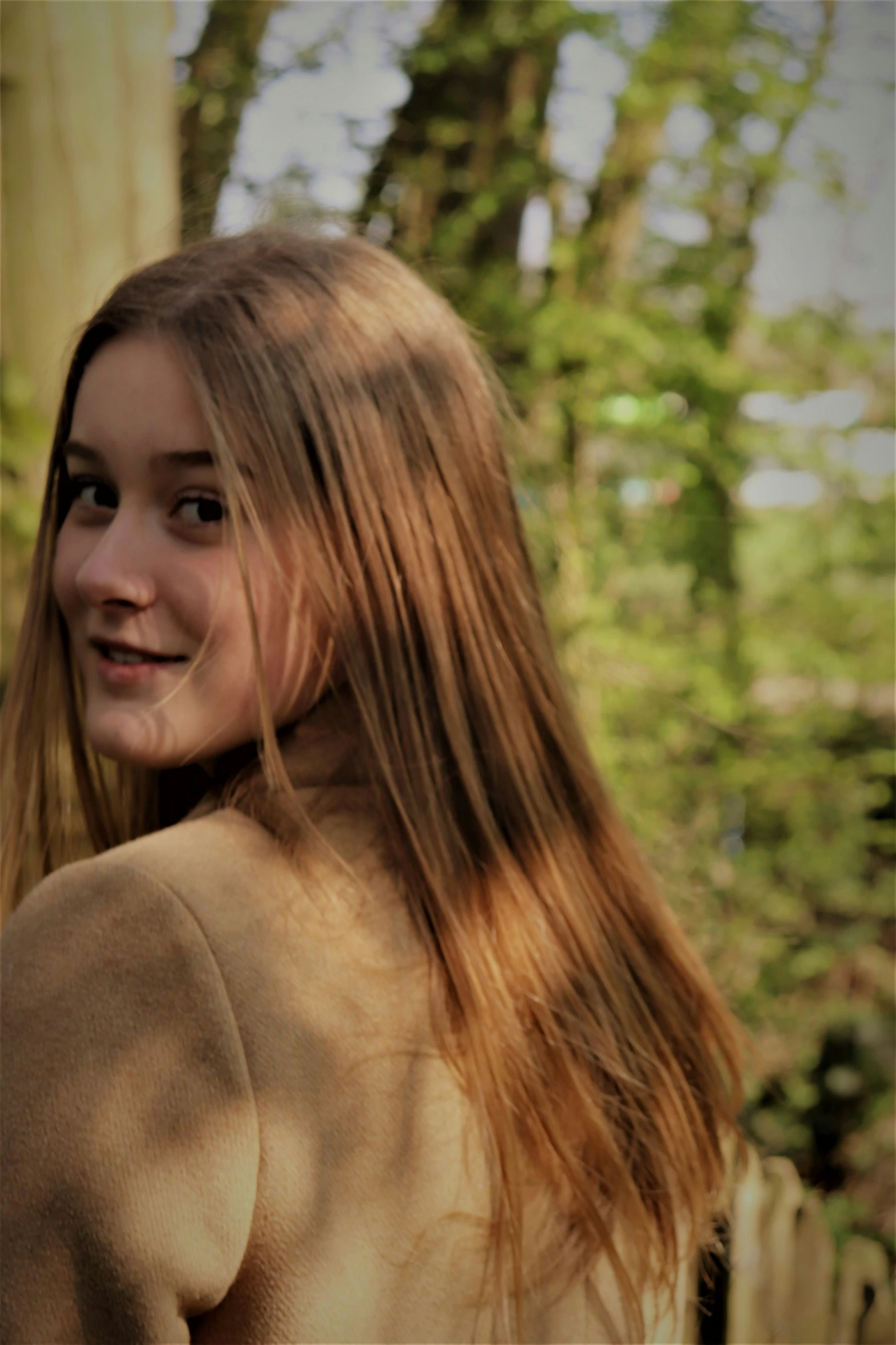 a  standing next to a fence with trees