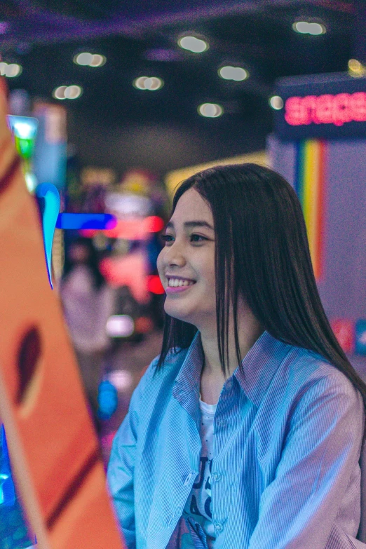 girl at indoor video game in entertainment center smiling