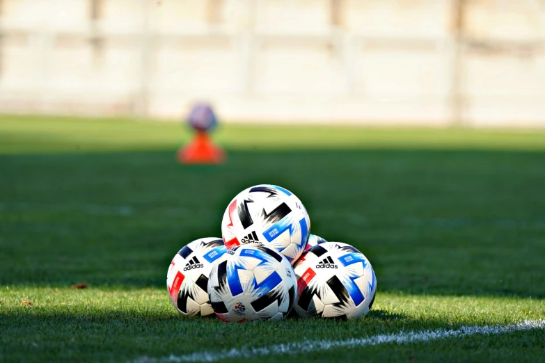 soccer balls sitting in the middle of a field