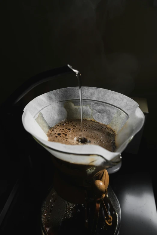 a metal pot filled with liquid on top of a stove