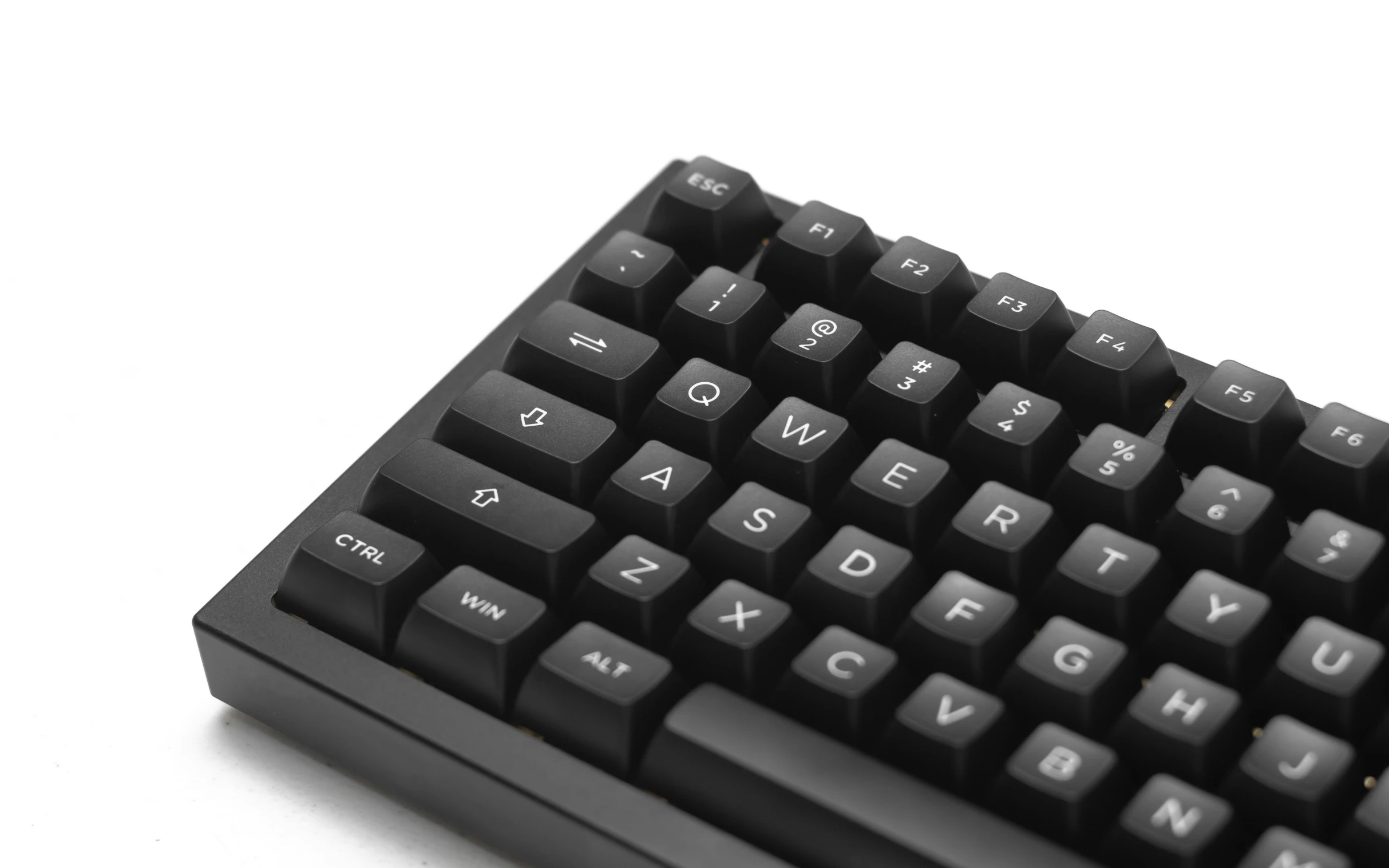 a close up of a black keyboard on a white surface