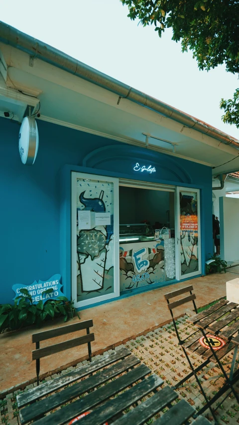 a blue building with wooden benches sitting outside