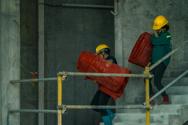 two people standing on stairs carrying red bags