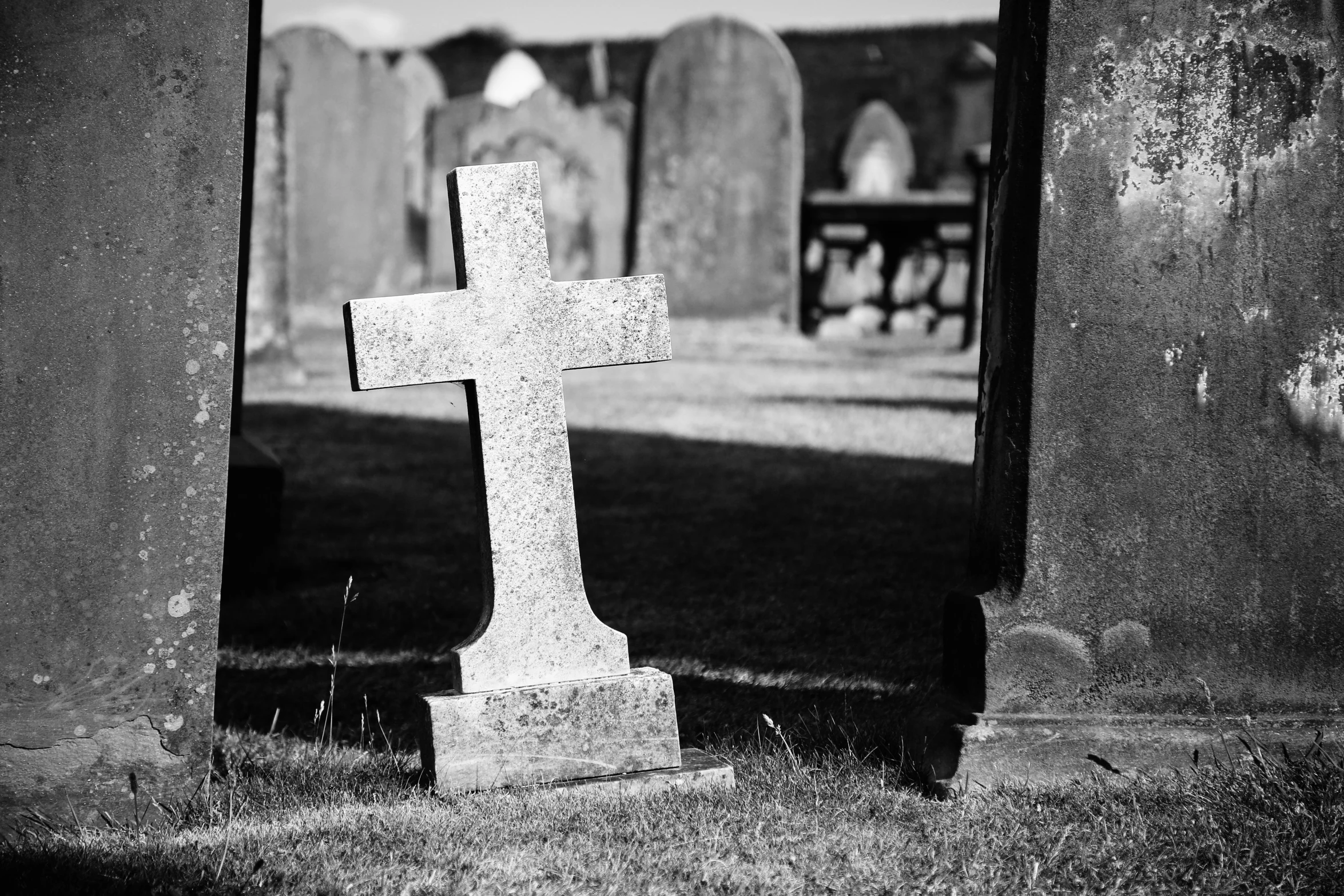 a very tall cross in the middle of some graves