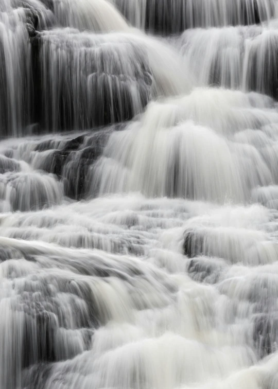 the water is flowing over the rocks of a waterfall