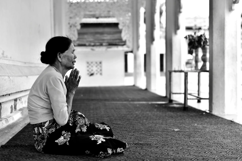 a woman sitting on the ground in a building