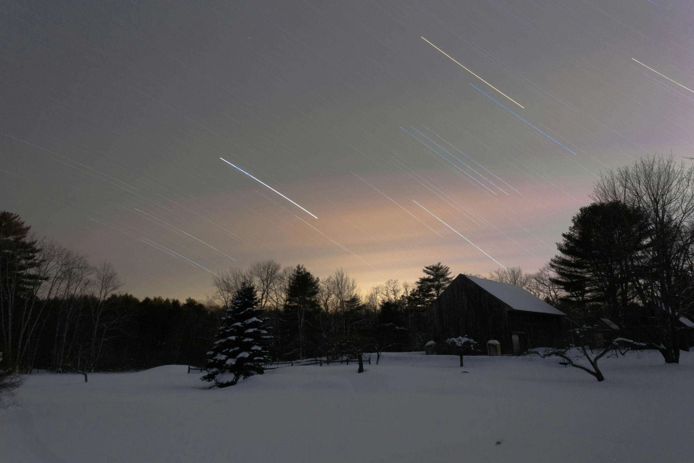 the sky is very dark with a streak of lights in it