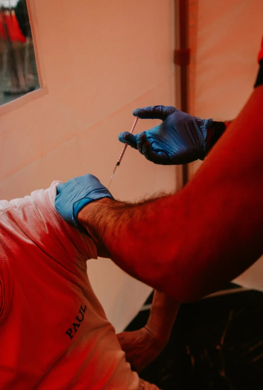 someone with gloved hands holding soing in front of a window