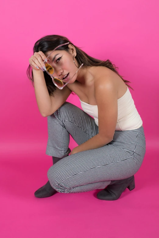 woman in a white tank top and striped pants posing for a camera