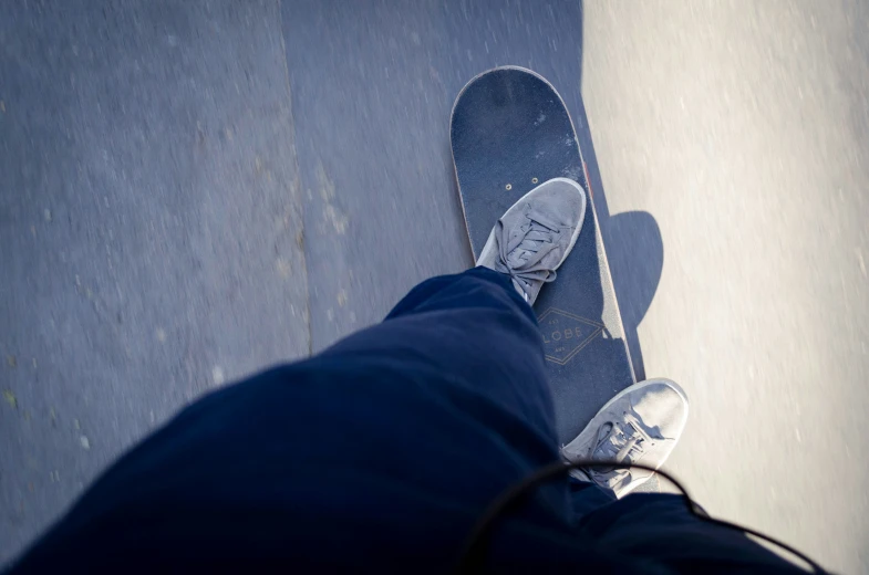 an aerial view from a person's feet with a skateboard in their lap