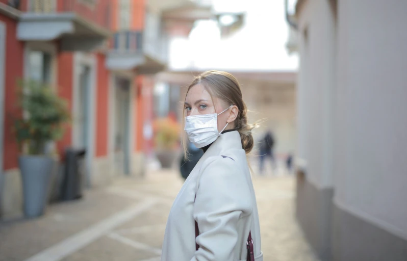 woman with face mask on walking down the street