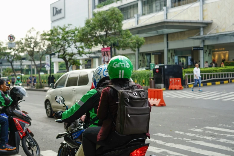 a man with a green helmet riding a motorcycle