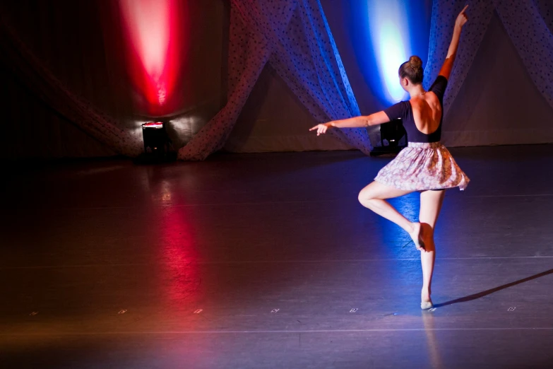 woman performing aerial dance with colorful lights in background