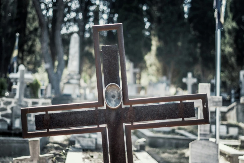 a wooden cross that is on the ground in a cemetery