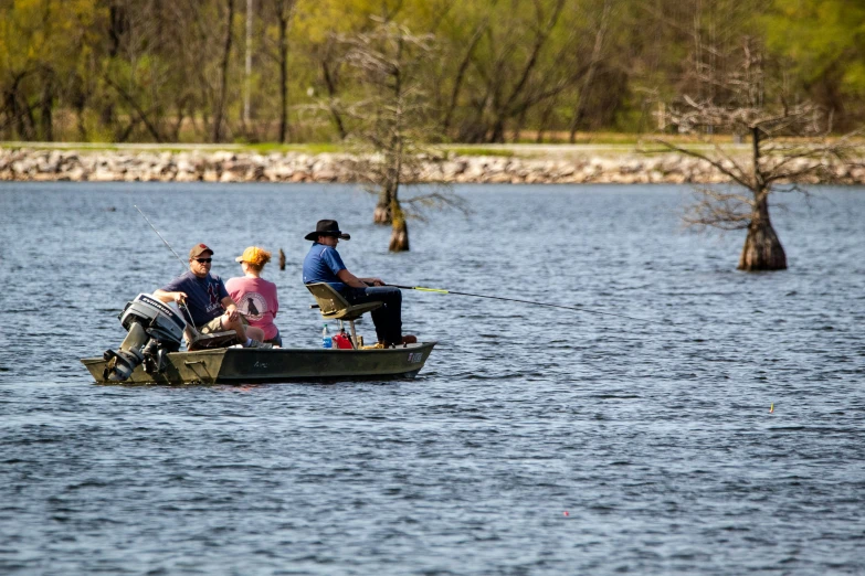 three people riding on the back of a small boat in a body of water