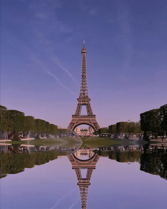 the eiffel tower stands next to water on a sunny day