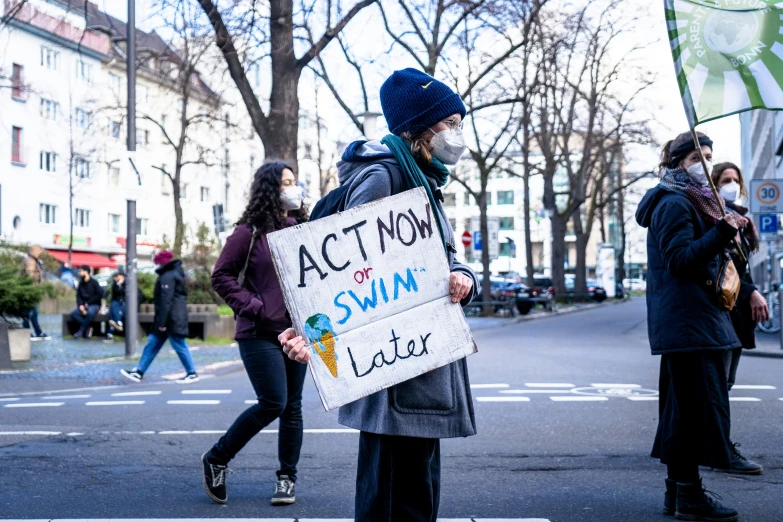 a man holding a sign that says act now