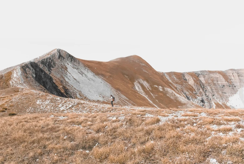 two people climb on a mountain ridge on their skis